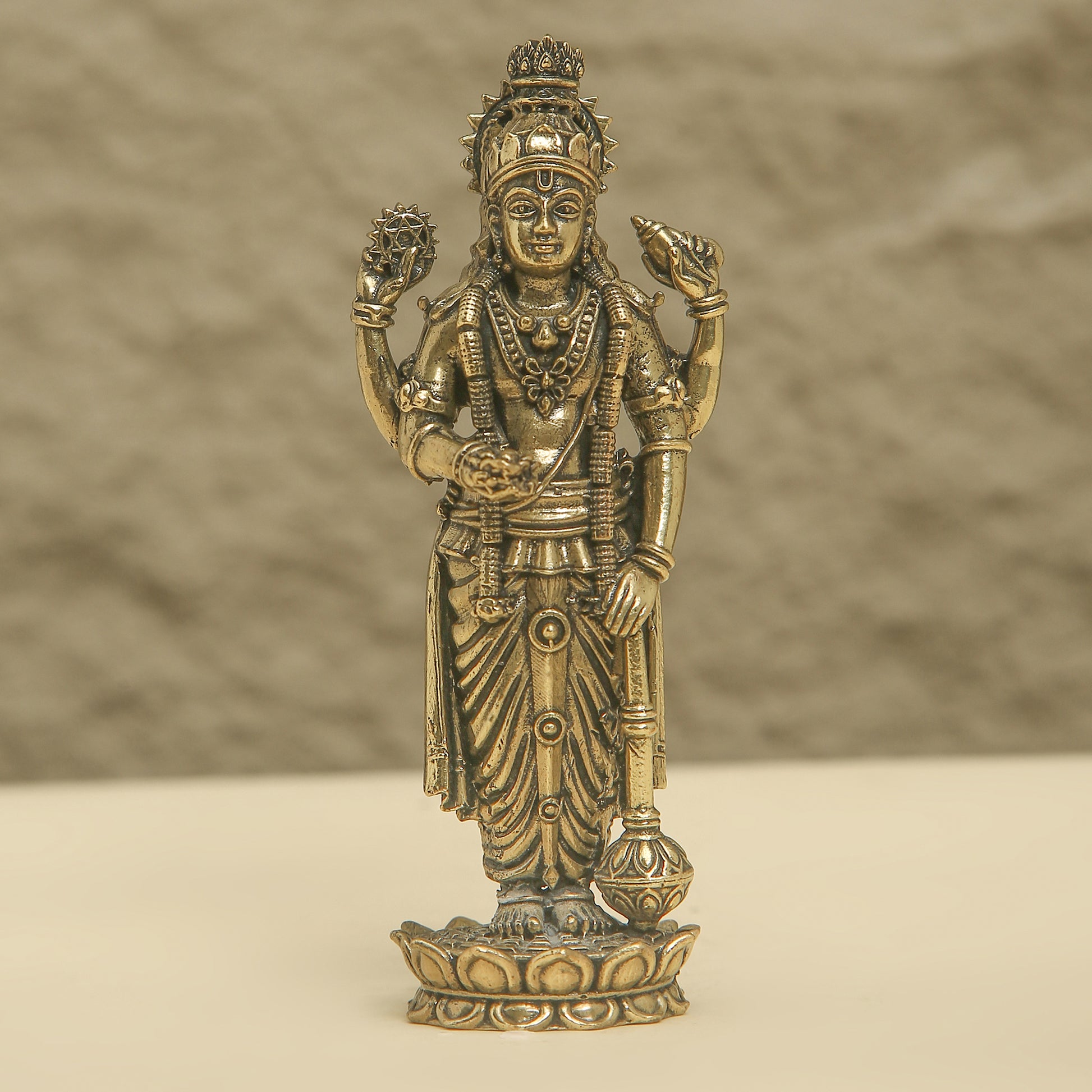 Bronze statue of a deity on a beige background