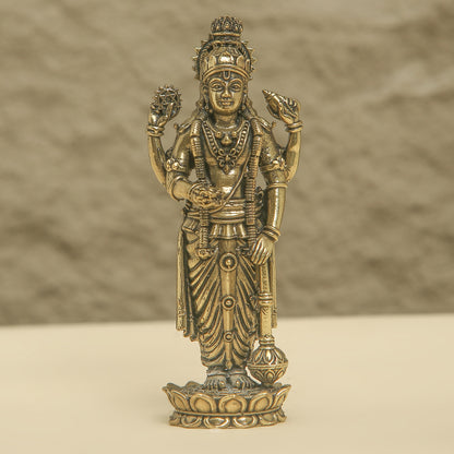 Bronze statue of a deity on a beige background