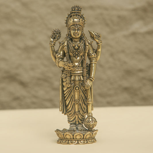 Bronze statue of a deity on a beige background