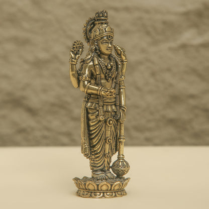 Bronze statue of a deity on a beige background