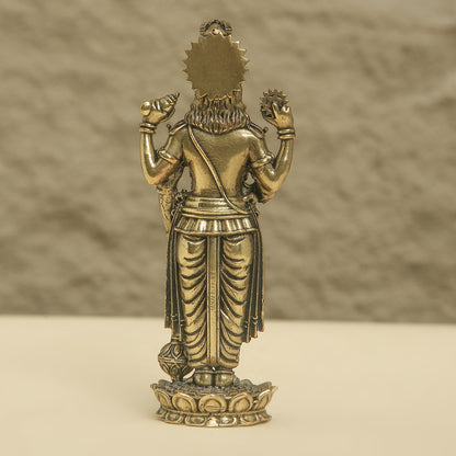 Bronze statue of a deity on a beige surface with a brown background