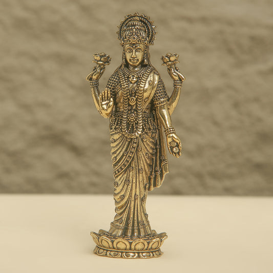 Bronze statue of a deity with intricate details on a beige background
