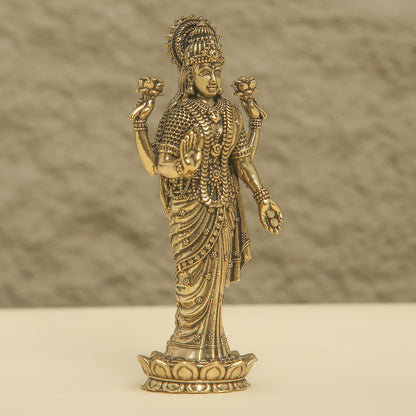 Bronze statue of a deity on a beige surface with a brown background
