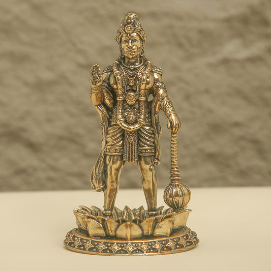 Bronze statue of a deity on a textured surface with a neutral background