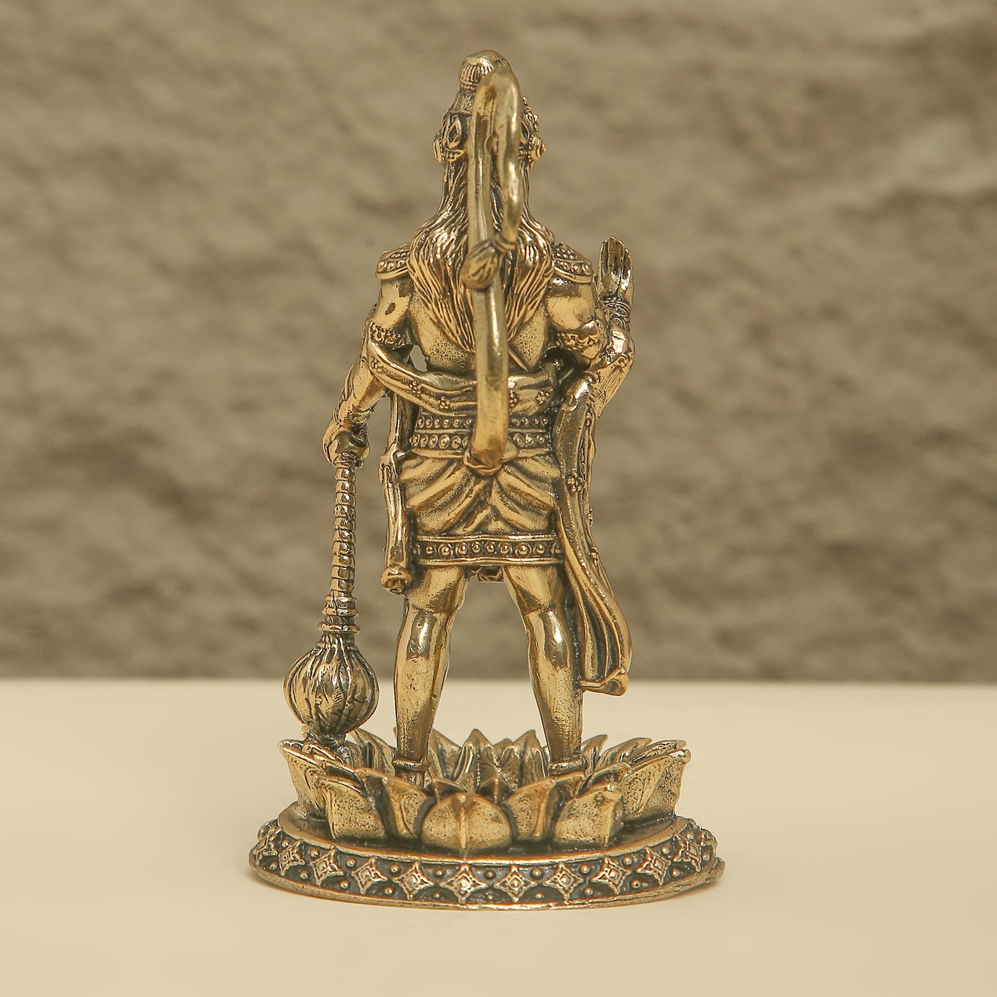 Bronze statue of a warrior on a lotus pedestal against a neutral background