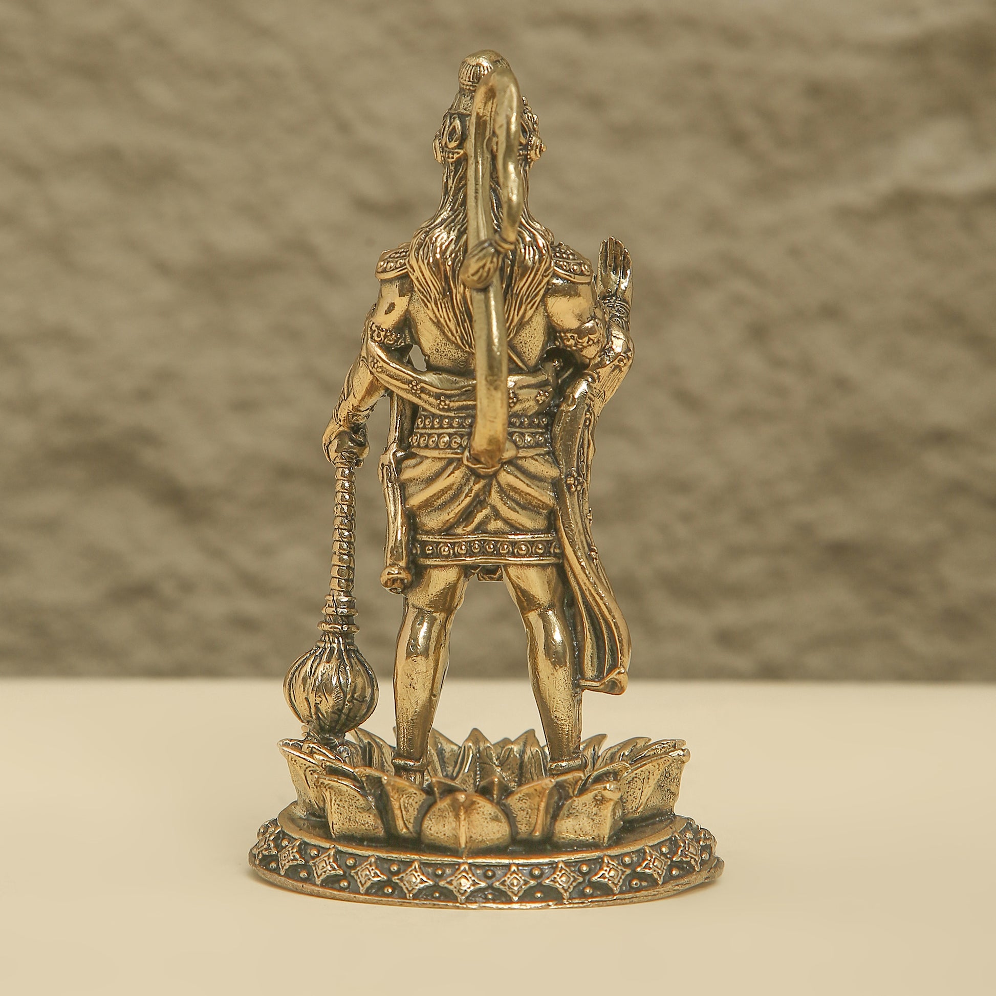 Bronze statue of a warrior on a lotus pedestal against a neutral background