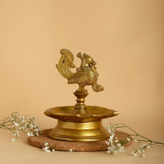 Brass lamp with rooster design on a beige background