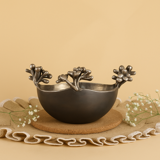 Decorative metal bowl with floral designs on a beige surface
