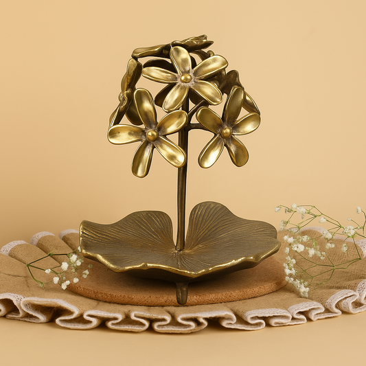 Bronze flower-shaped jewelry stand on a beige background