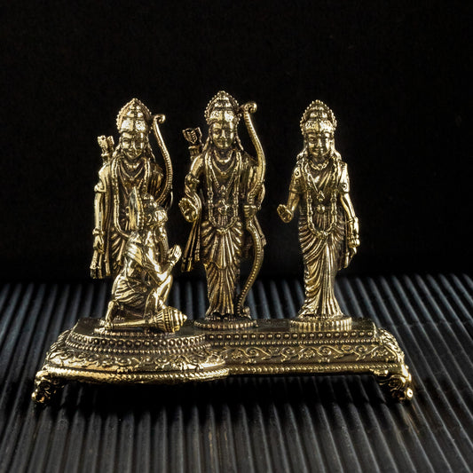 Bronze statue of three figures on a textured black surface