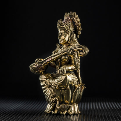 Gold-colored statue of a deity on a black background