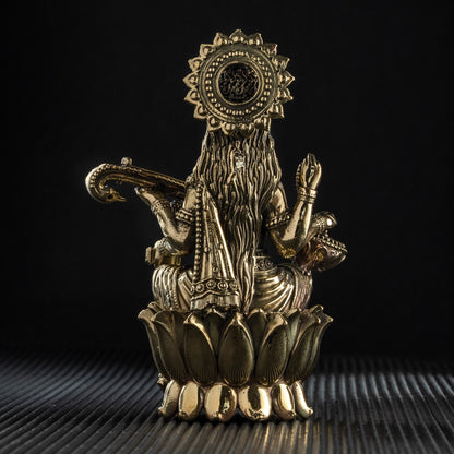 Decorative brass statue on a textured surface with a black background