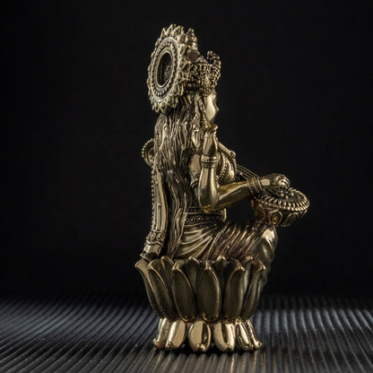 Bronze sculpture of a figure with a crown on a textured surface with a black background