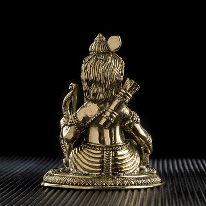 Brass statue of a seated figure with a dark background