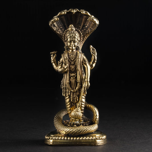 Gold-colored statue of a deity with a dark background