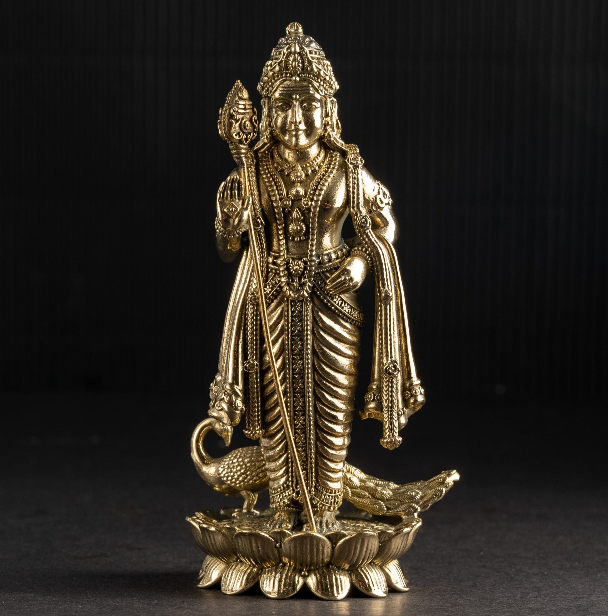 Gold-colored statue of a deity on a black background