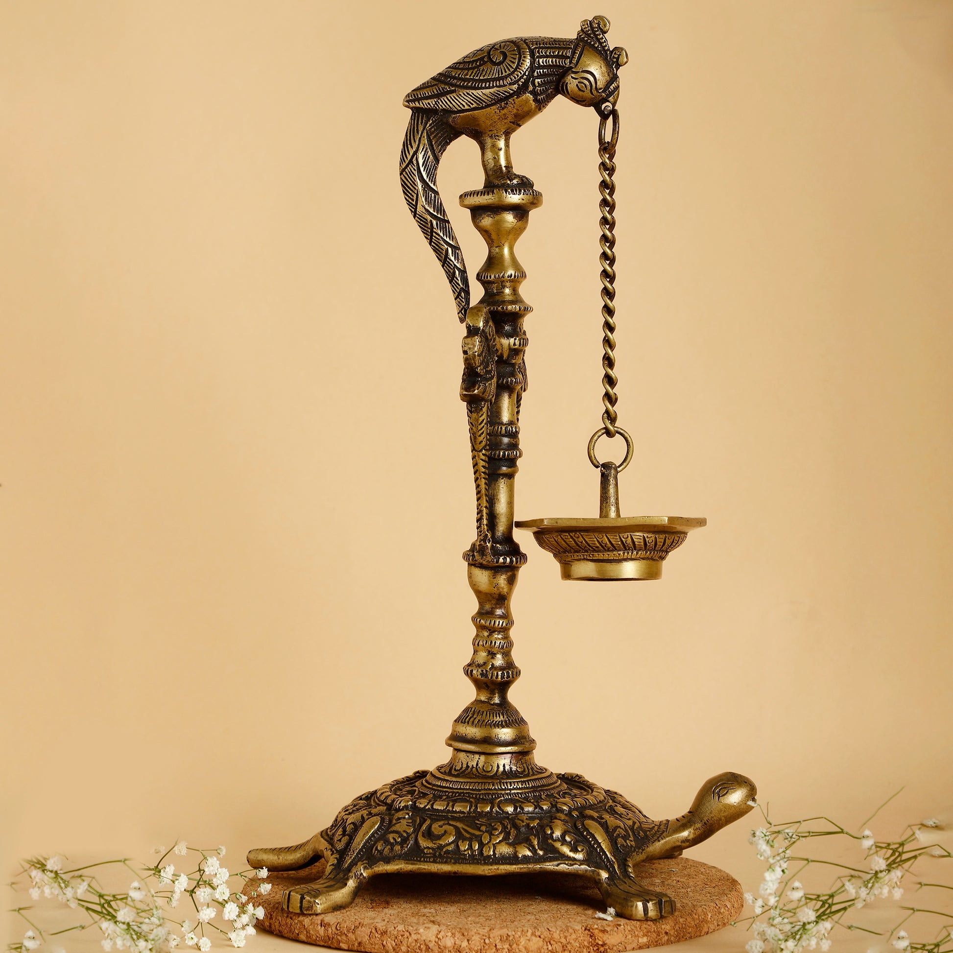 Decorative brass lamp with bird and turtle design on a beige background