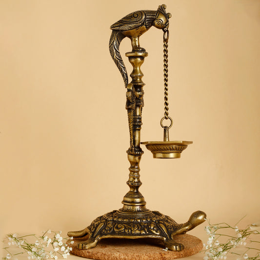 Decorative brass lamp with bird and turtle design on a beige background