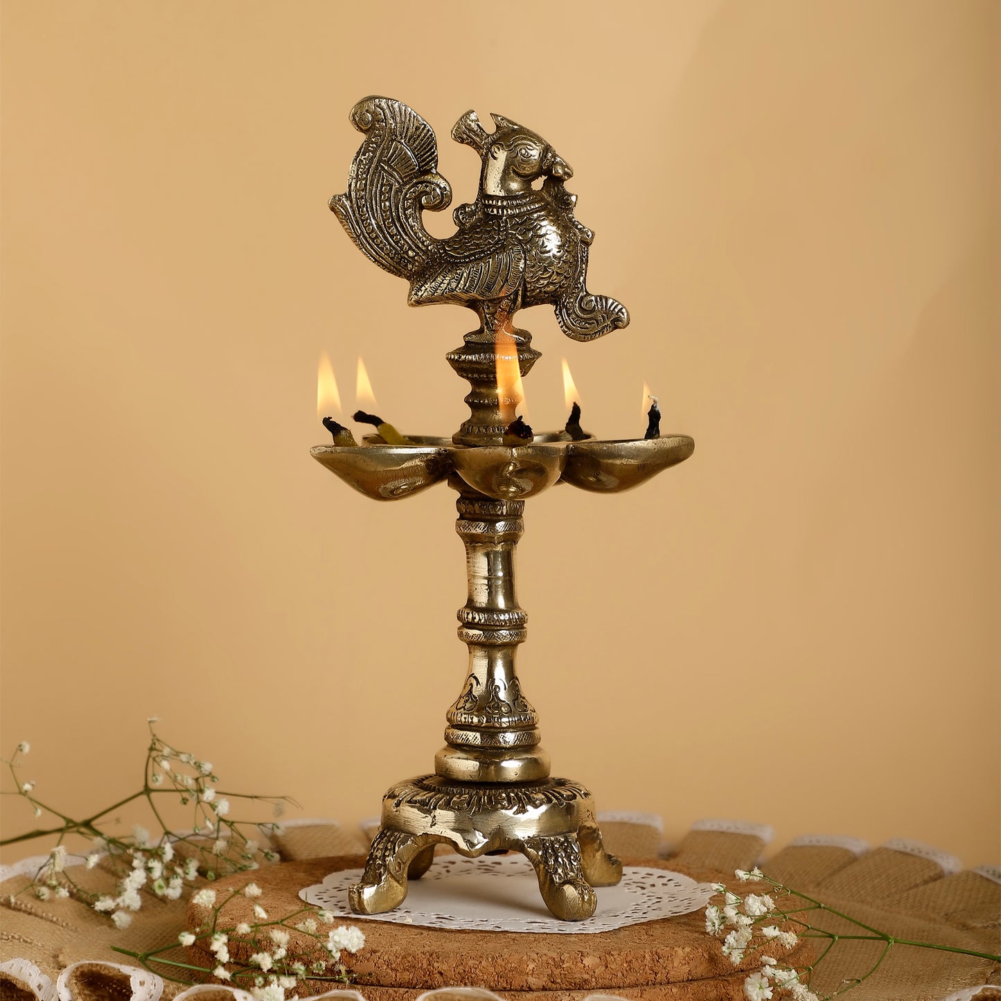 Decorative brass lamp with candles on a textured surface and beige background
