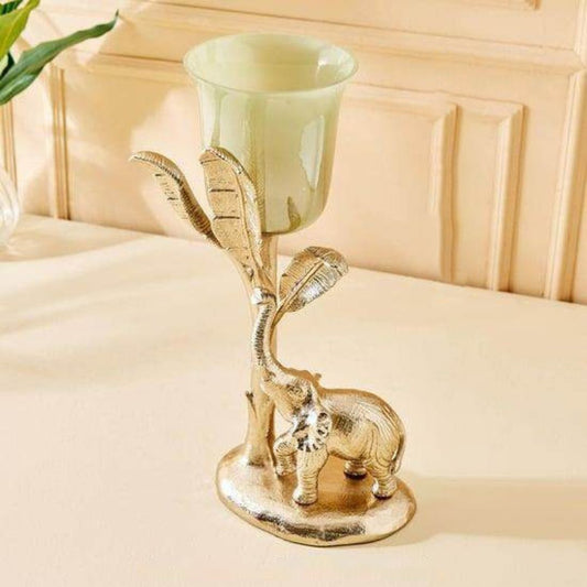 Decorative candle holder with elephant design on a beige surface