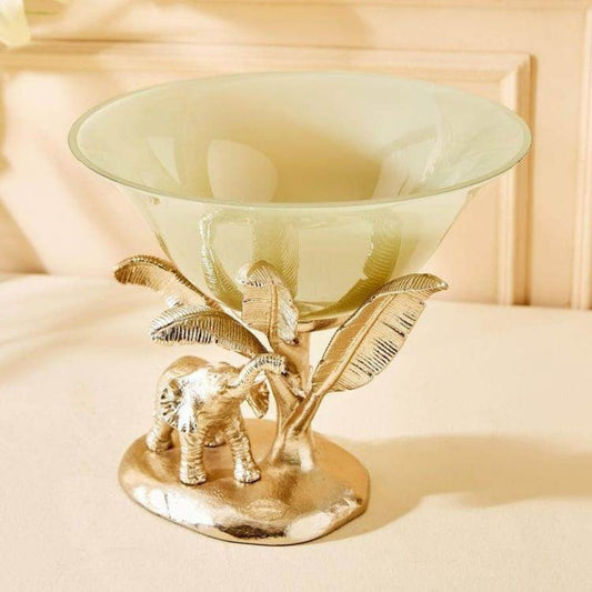Decorative glass bowl with gold elephant and leaf design on a beige background