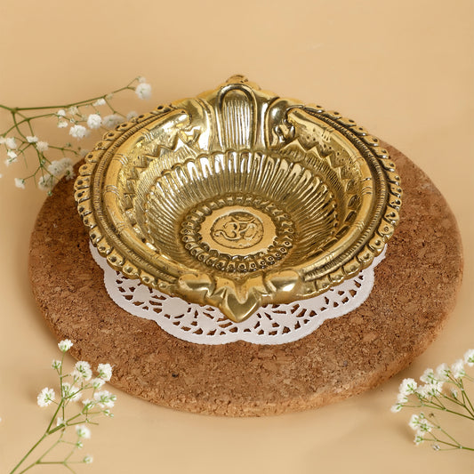 Decorative gold bowl on a cork surface with white flowers