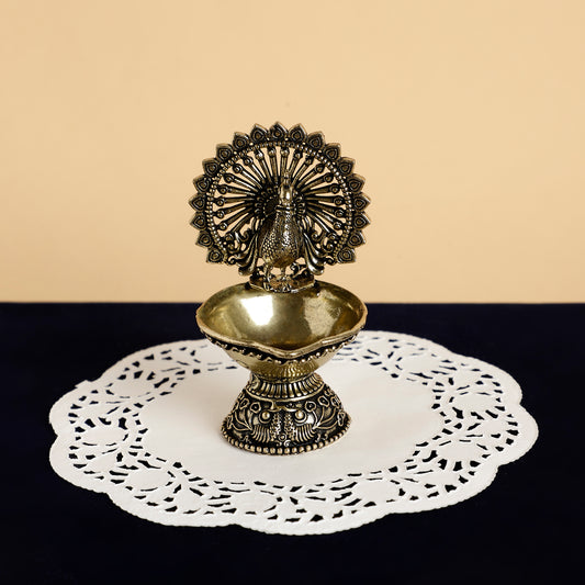 Decorative metal oil lamp on a doily with a beige and black background