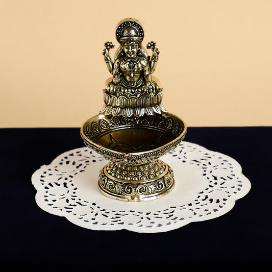 Decorative metal statue on a white doily with a beige background