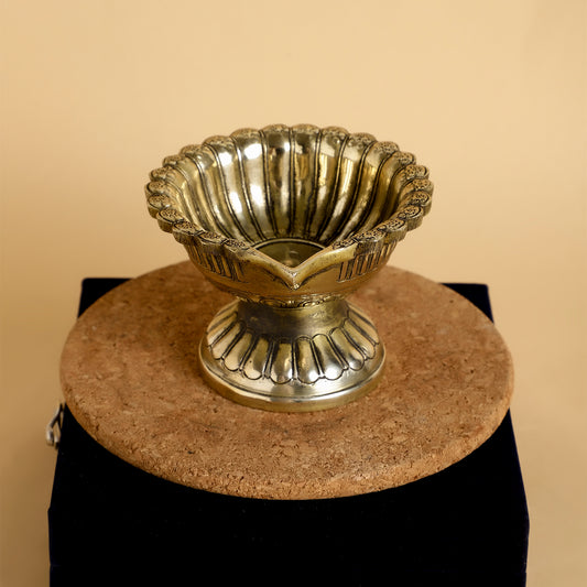 Decorative metallic bowl on a stand with a beige background