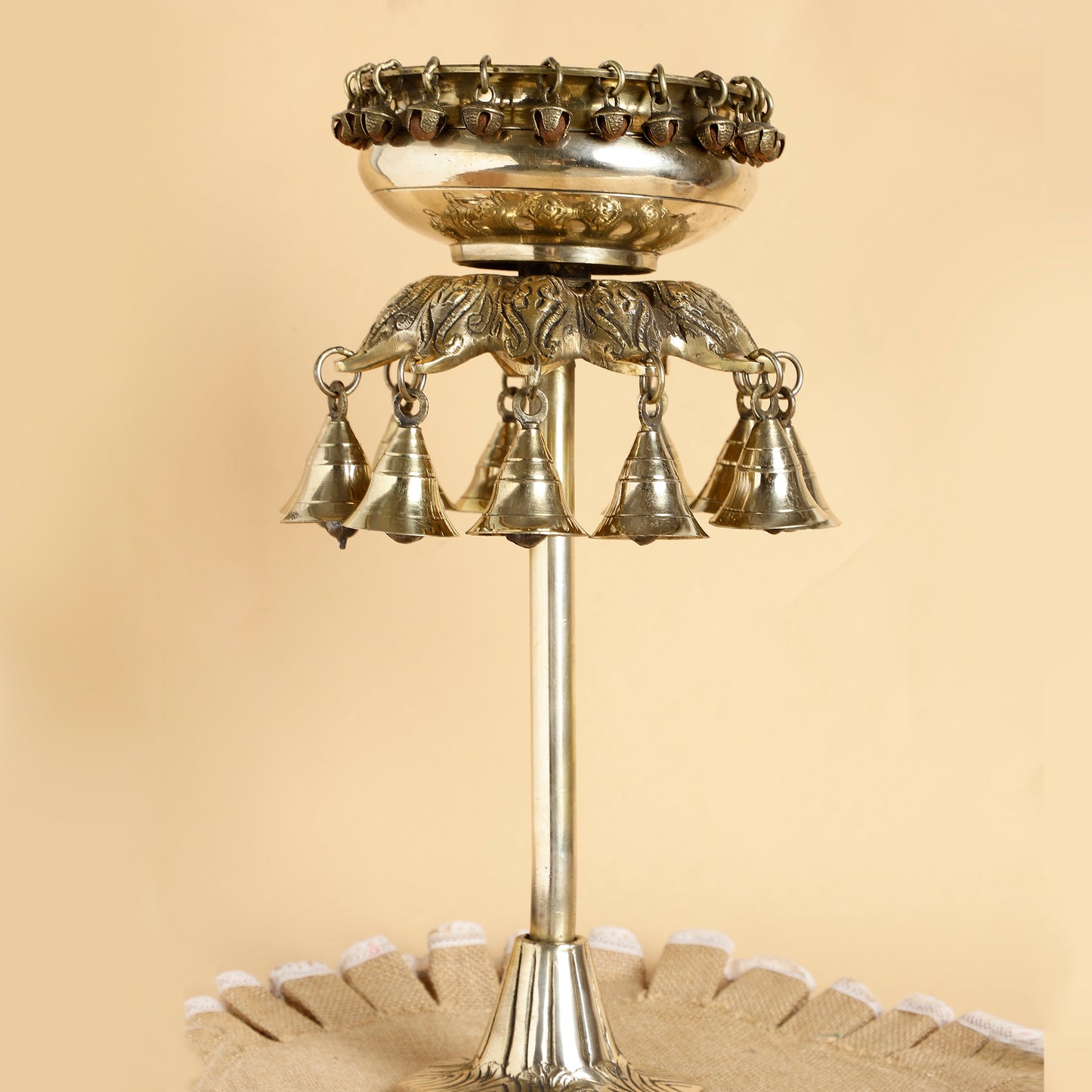 Decorative metal bell structure on a beige background