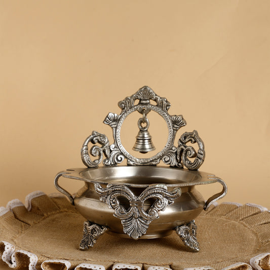 Decorative metal bowl with intricate designs on a beige background