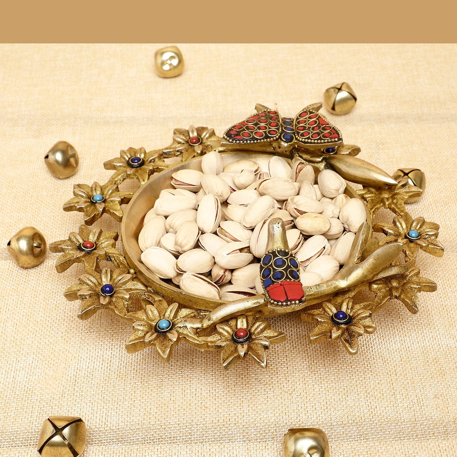 Decorative dish with stones and small figurines on a beige background