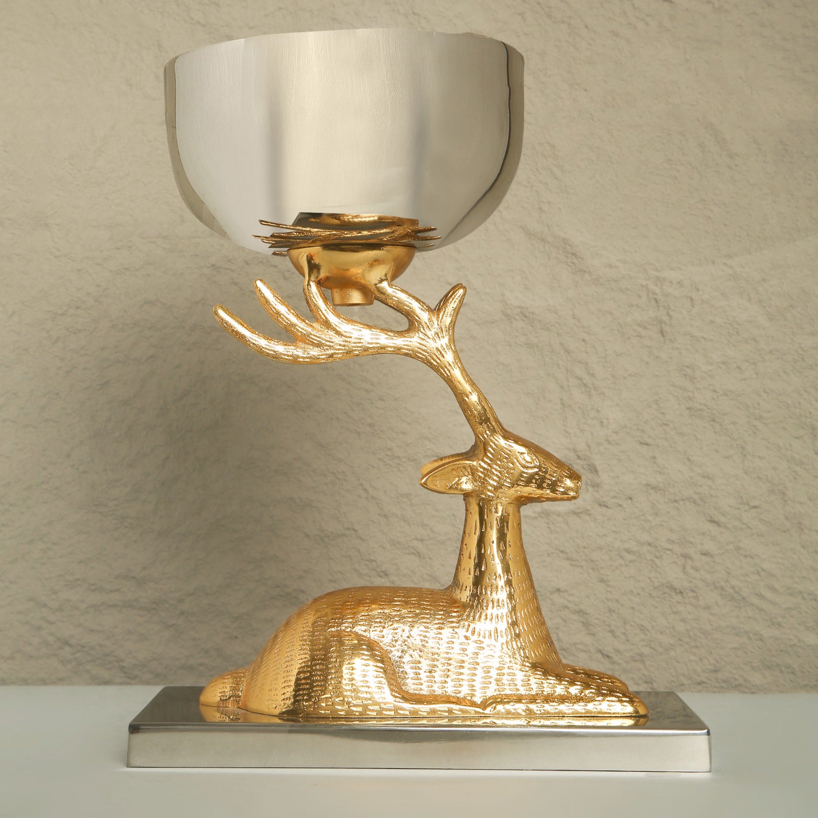 Decorative lamp with gold deer design on a neutral background