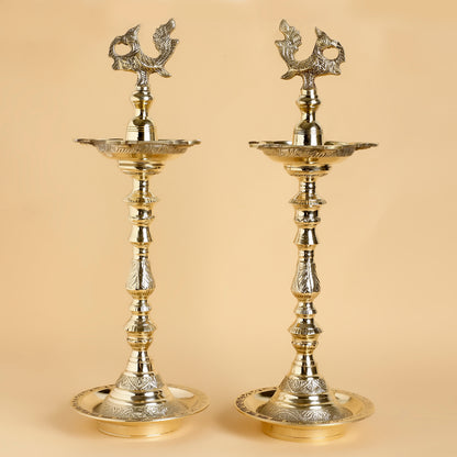 Two ornate brass lamps on a beige background