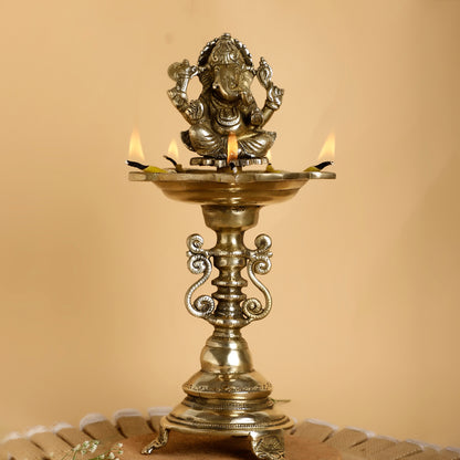 Decorative oil lamp with a figurine on top against a beige background
