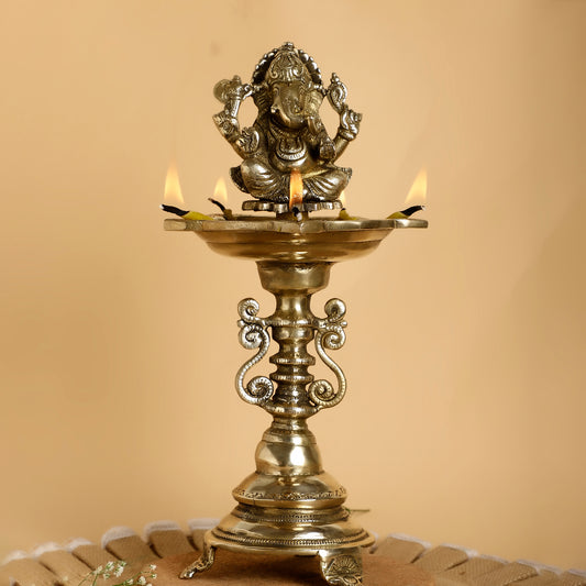 Decorative oil lamp with a figurine on top against a beige background
